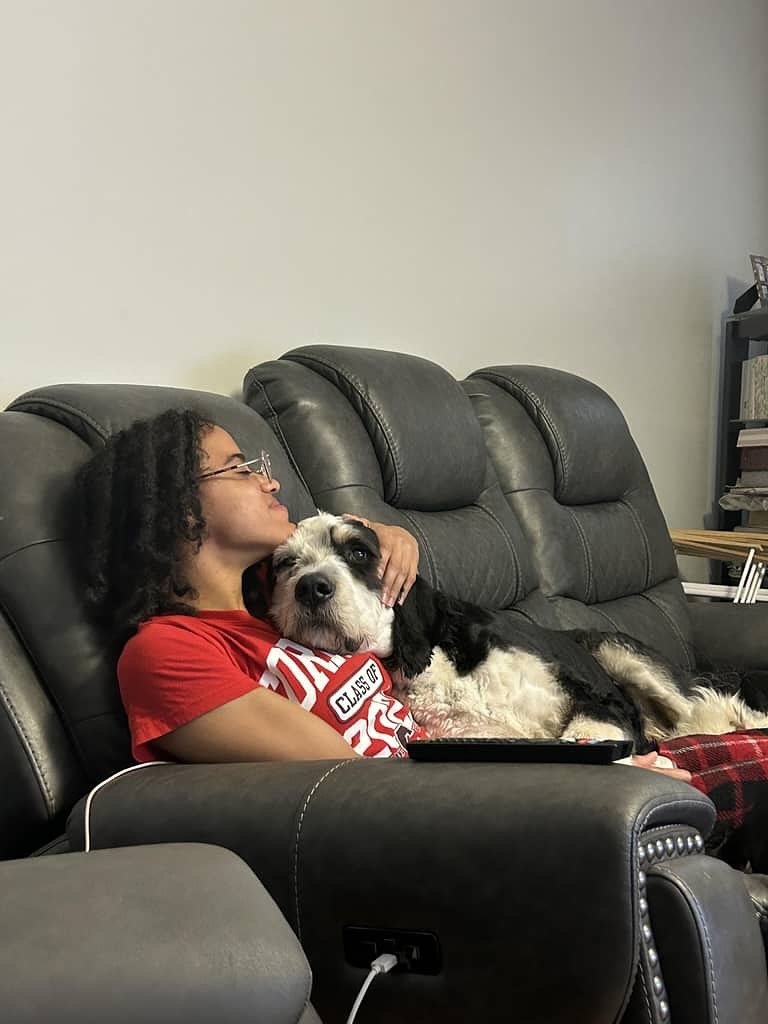 Mia sitting with a happy dog